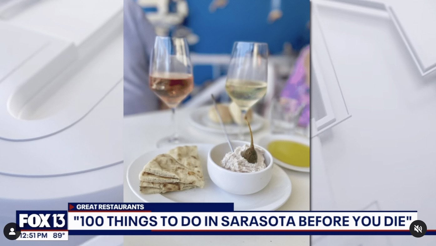 Image of show on television with food and wine in photo.